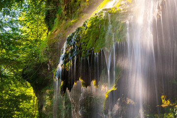 The Urach waterfall on the edge of the Swabian Alb is a high waterfall with tufa deposits. Detail with long exposure effect after heavy rain in summer. Popular tourist attraction in a natural reserve.
