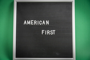 American First message on black letter board. Close-up view of the words “American First”...