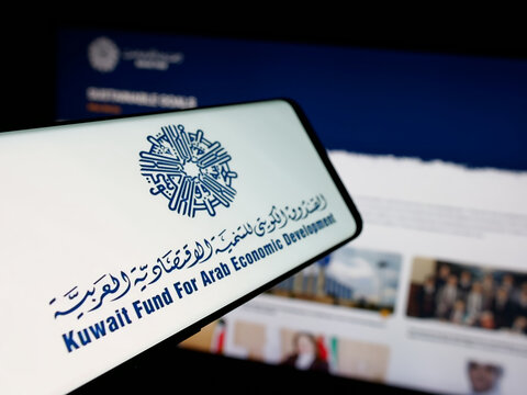 Stuttgart, Germany - 06-18-2025: Smartphone with logo of Kuwaiti arab economic development fund KFAED on screen in front of website. Focus on center-left of phone display.