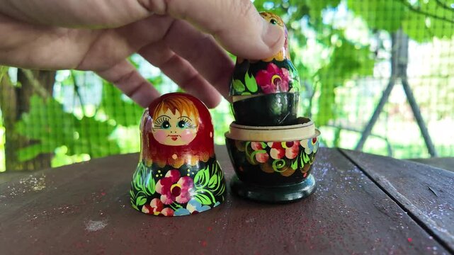 wooden matryoshka doll. Hand Holding a Wooden Matryoshka Doll &ndash; Traditional Russian Nesting Doll. Collection of traditional Russian nesting dolls. Beautiful handmade matryoshka dolls in a row.