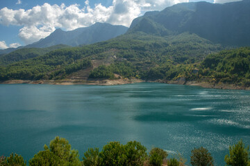 Turquoise mountain lake under cumulus clouds, scenic nature view