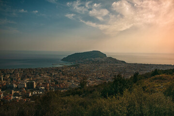 Aerial view of coastal city at golden hour with clouds