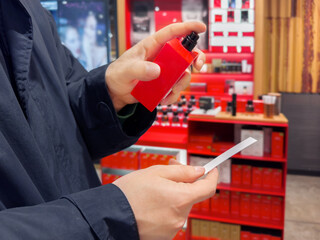 Man buying make up at cosmetics section in store. choosing cosmetics, perfumes, creams and shampoos, Using tester.