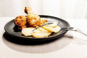 Baked chicken with vegetable sauce and sliced potatoes.