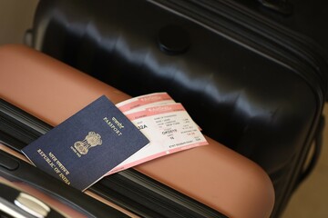 Indian passport with tickets lies on touristic suitcase close up in airport waiting hall