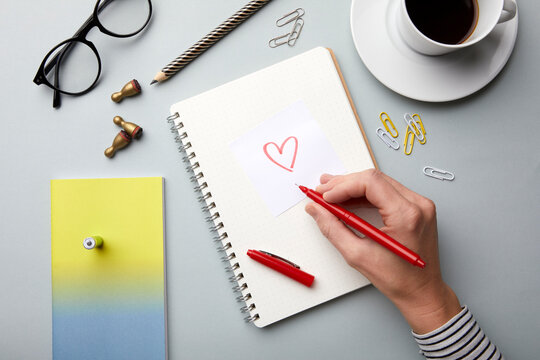 A clean and organized workspace with a notebook and a heart drawing.