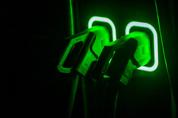 Detail of cable of public charging station for electric cars. Illuminated night charger for zero emission car. Electric connect