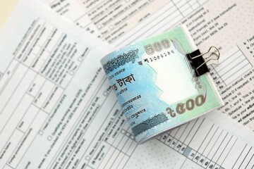 Bangladeshi taka money bills in big amount lies on table with tax forms close up