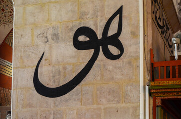 A large wall with a black and white drawing of a crescent moon. The crescent moon is surrounded by...