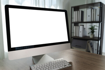 Computer with blank screen on table modern desktop computer with large screen and keyboard wooden desk bright office space. background features