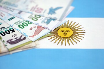 Argentine pesos money bills in big amount lies on Argentina flag close up