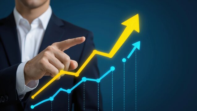 Businessman points to upward trending yellow and blue graphs indicating financial growth and success - Powered by Adobe