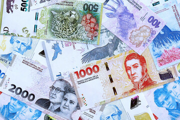Argentine pesos money bills in big amount lies on white table close up. Finance and banking concept