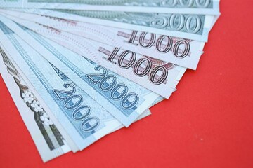 North Korean won money bills in big amount lies on red color table close up