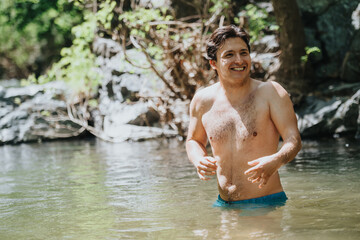 Man happily swimming in a refreshing natural stream surrounded by greenery and rocks. Captures joy...