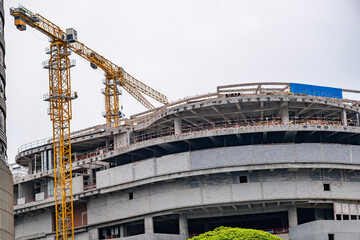 Construction site background. Industrial crane near bulding. Concrete building under construction.