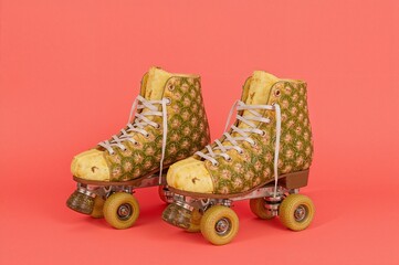 Yellow Roller Skates with Pineapples Inside on Red Background