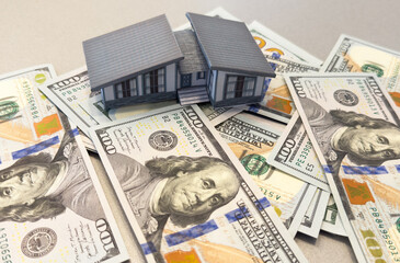 House standing on a pile of dollar bills. Investment, real estate and property concept