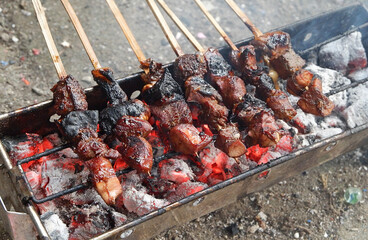 Top view of Sate or satay, traditional food from Indonesia is being grilled on fiery charcoal.