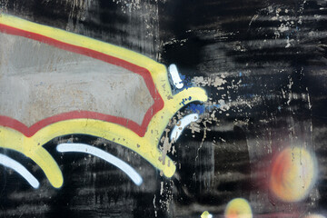 Black, gray letters with red, yellow, and orange spheres, thick lines with red borders, black spheres. A drawing, graffiti depicting word OBM is applied to a gray, brown concrete fence.