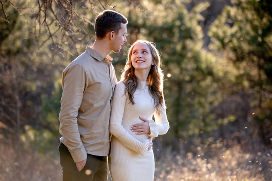 A Couple Joyfully Celebrating Their Pregnancy Announcement Surrounded by Beautiful Nature