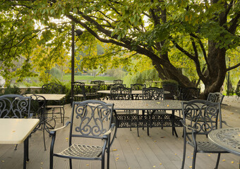 table and chairs of a street cafe in autumn leaves.