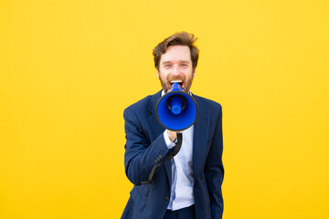 Businessman with megaphone against yellow background