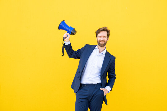 Businessman with megaphone against yellow background