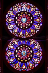 Vibrant stained glass rose window, a kaleidoscope of colors and intricate design.
