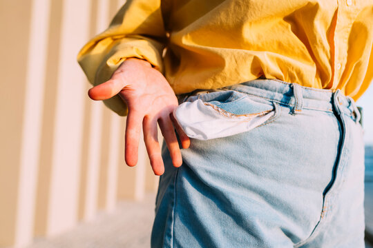 Young woman showing empty pocket of jeans