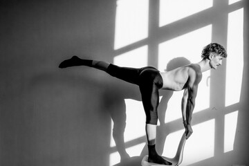 Male ballet dancer performing a graceful pose indoors in Berlin, Germany