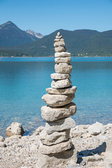 cairn at the lake shore of blue lake Walchensee, stone pile. upper bavaria