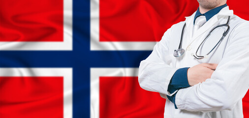 Norway healthcare concept. Male doctor on Norway flag. Doctor with crossed arms on Norway flag