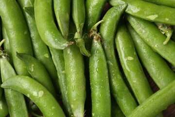 Fresh ripe green peas on wooden table, flat lay