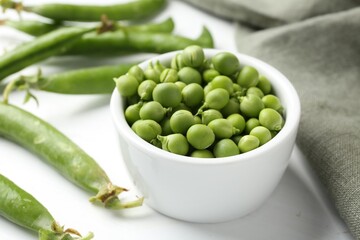 Fresh ripe green peas on white wooden table, closeup