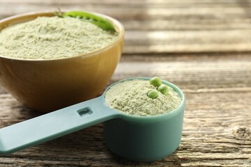 Protein powder and fresh peas on wooden table, closeup