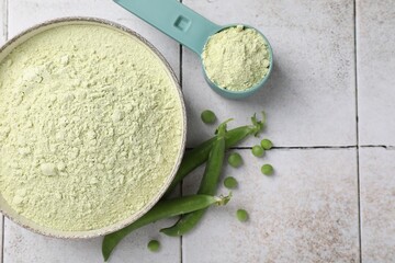 Protein powder and green peas on light tiled table, flat lay. Space for text