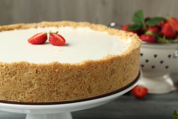 One tasty cheesecake with strawberry on grey table, closeup