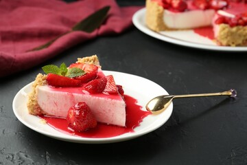 Piece of tasty cheesecake with strawberries, sauce and mint on black table, closeup