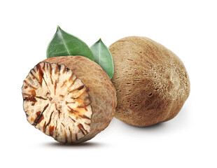 Nutmeg seeds with green leaves on white background. Aromatic spice