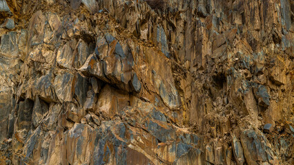 Rugged brown sedimentary cliff, full-frame closeup