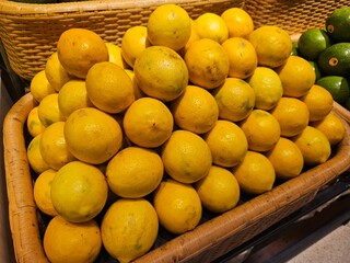 Fresh lemons arranged in a rustic display basket, ready for customers. Perfect for organic food...