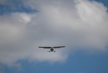 einmotoriges Flugzeug - Leichtflugzeug in der Luft vor blauem Himmel und weiße Wolken
