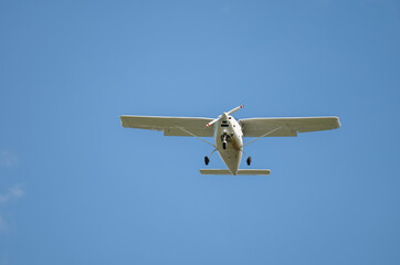 einmotoriges Flugzeug - Leichtflugzeug in der Luft vor blauem Himmel und weiße Wolken
