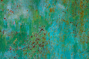 Weathered green metal surface with rust and peeling paint outdoors