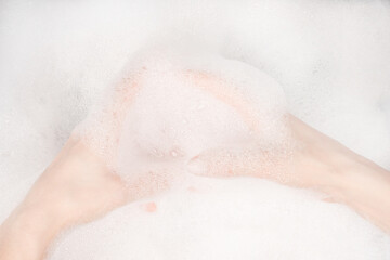 Female hands in foam close-up. girl's hands in soap foam. washing, cleaning, washing dishes