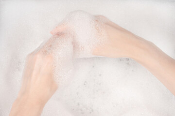 Female hands in foam close-up. girl's hands in soap foam. washing, cleaning, washing dishes