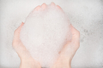 Female hands in foam close-up. girl's hands in soap foam. washing, cleaning, washing dishes