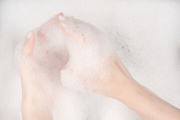 Female hands in foam close-up. girl's hands in soap foam. washing, cleaning, washing dishes