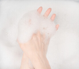 Female hands in foam close-up. girl's hands in soap foam. washing, cleaning, washing dishes